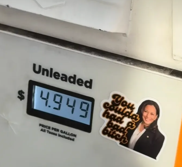 Bensinpumpe viser pris $4,949 per gallon, med et klistremerke av en ukjent person og tekst som sier 