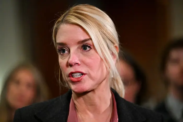 En person i et formelt antrekk som snakker i offentlige omgivelser med andre uskarpt i bakgrunnen