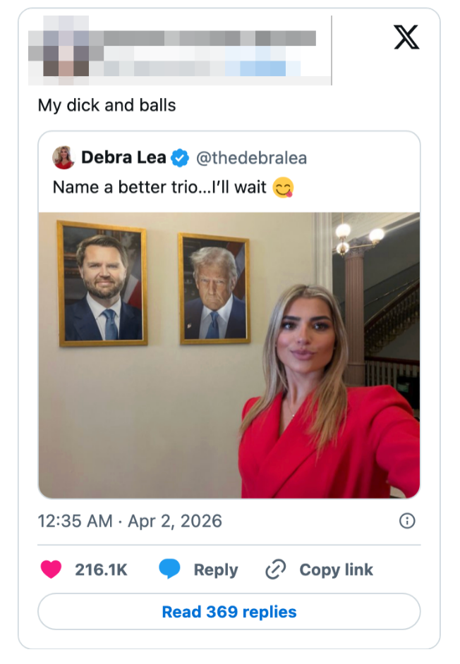 En kvinne i rødt antrekk tar en selfie foran innrammede portretter av to menn