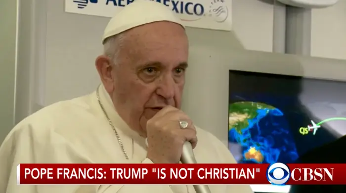 Pave Frans snakker i en mikrofon med et bekymret uttrykk under et CBSN-nyhetssegment. Teksten nedenfor lyder: "Pave Frans: Trump 'Is Not Christian'."