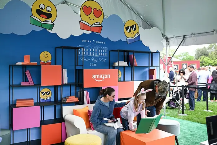 Familie på Amazon lesebod med fargerike emoji-dekorasjoner på et offentlig arrangement