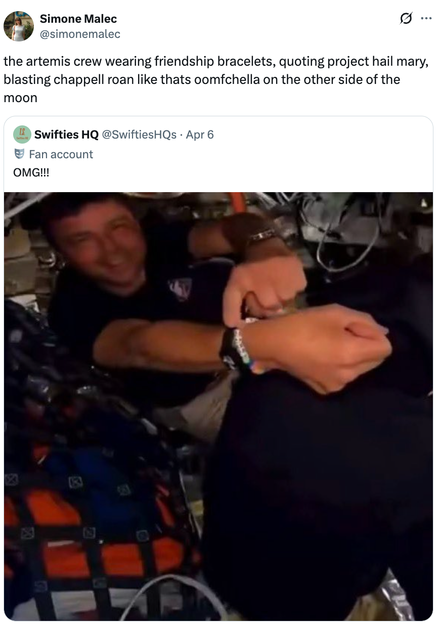 Smilende person i et svakt opplyst miljø holder på et stort utstyr, iført et vennskapsarmbånd