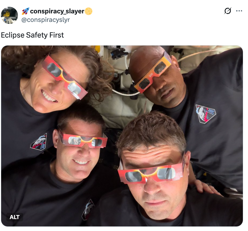 Fire personer med beskyttelsesbriller smiler mens de forbereder seg på å se en solformørkelse innendørs