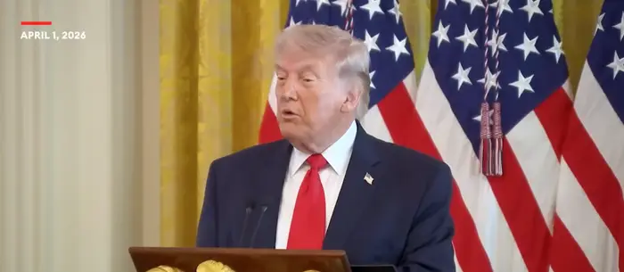 Donald Trump taler ved et podium i Det hvite hus under en påskelunsjbegivenhet, med amerikanske flagg i bakgrunnen