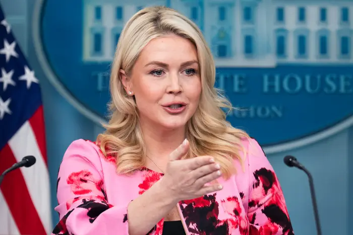 En person snakker på et podium foran et emblem fra Det hvite hus, iført en blomstermønstret jakke