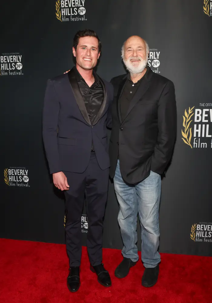 To menn på Beverly Hills Film Festivals røde løper. Den ene har på seg en formell dress, den andre en blazer med jeans, begge smiler til kameraet