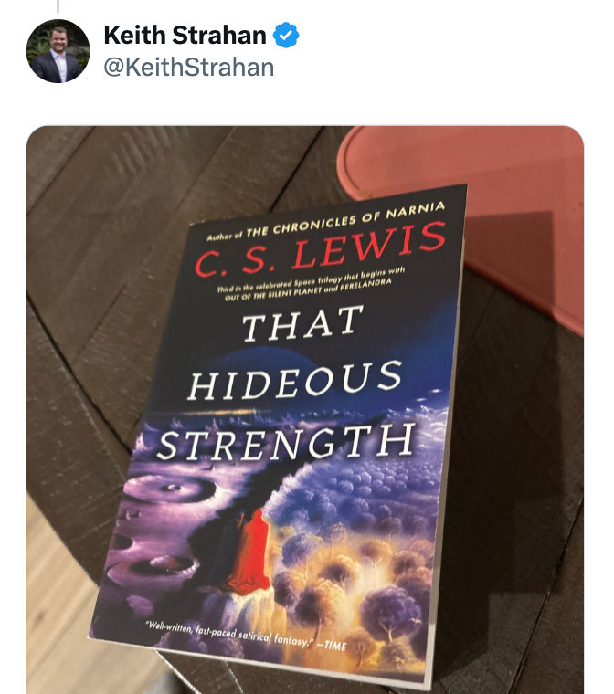 "Foto av CS Lewis bok 'That Hideous Strength' på et trebord, med fokus på omslagskunsten med et mystisk landskap."