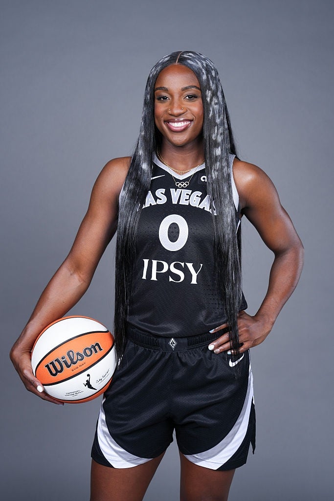 Basketballspiller i Las Vegas-lagdrakt, holder en ball og smiler selvsikkert