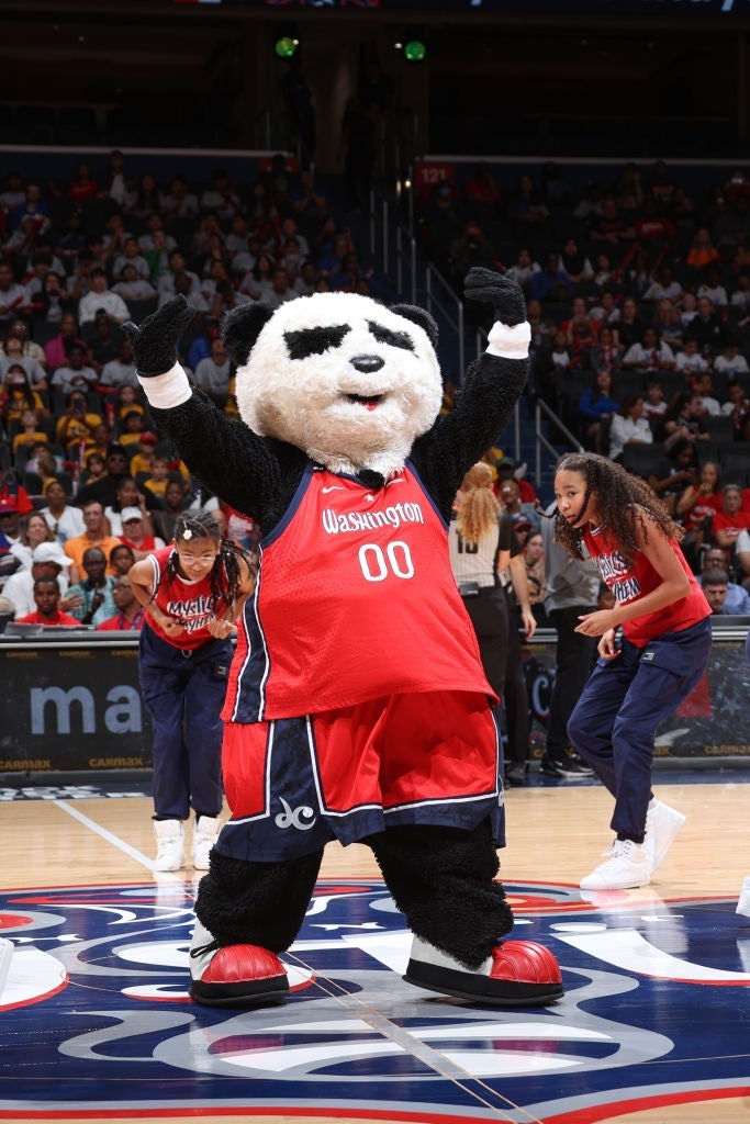 Basketballmaskot, kledd som en panda i en trøye, underholder fansen på banen under en kamp