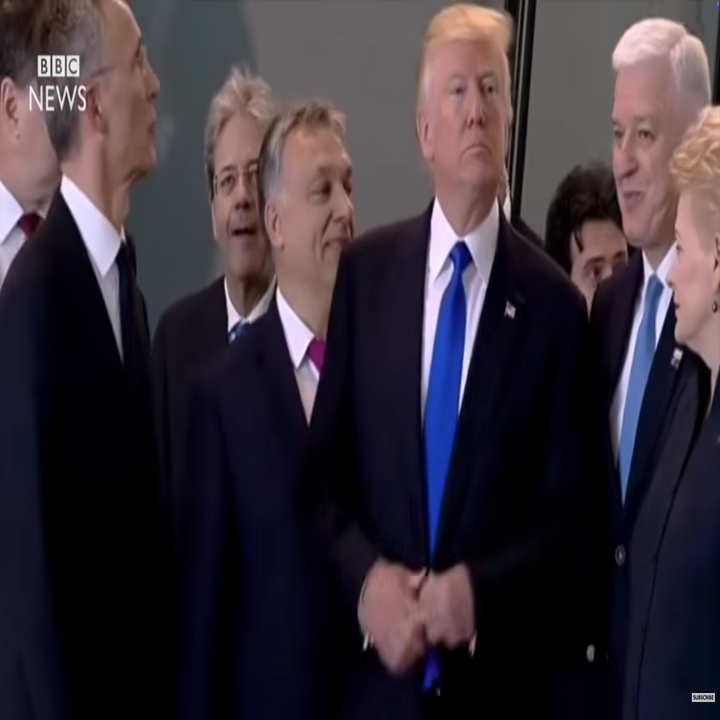 Gruppe politiske ledere som står sammen på et formelt arrangement, inkludert en mann i dress og blått slips