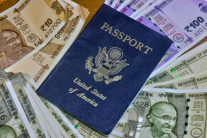 Amerikansk pass omgitt av ulike valører av indiske valutasedler med Mahatma Gandhi