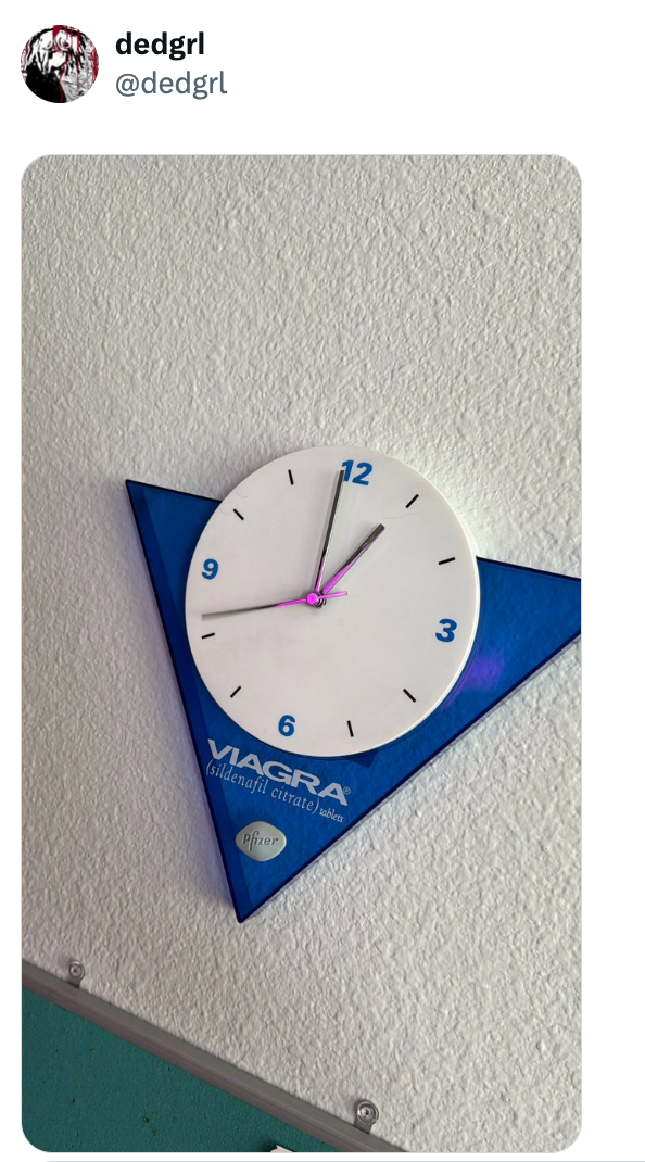 En veggklokke i form av en trekant med Viagra-logoen tydelig vist nederst