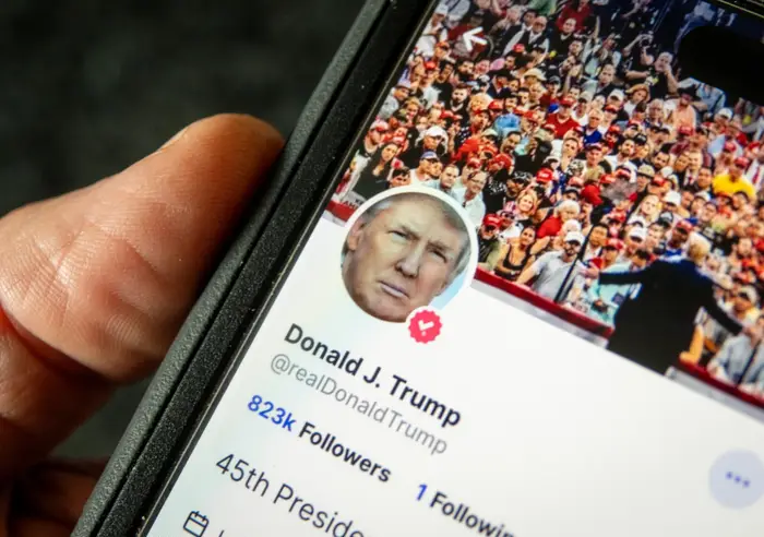 Smarttelefon som viser en sosial medieprofil med et folkebilde