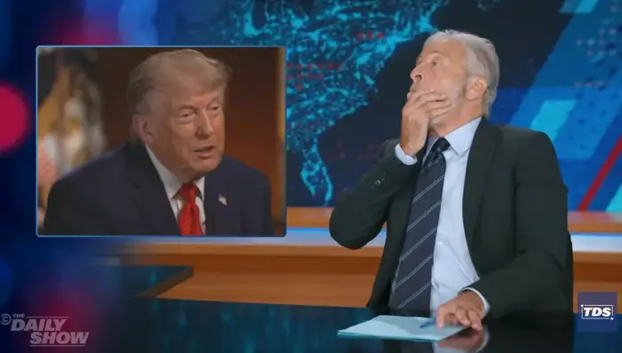 TV-verten reagerer humoristisk mens han ser på en video av en politisk skikkelse på et nyhetstalkshow