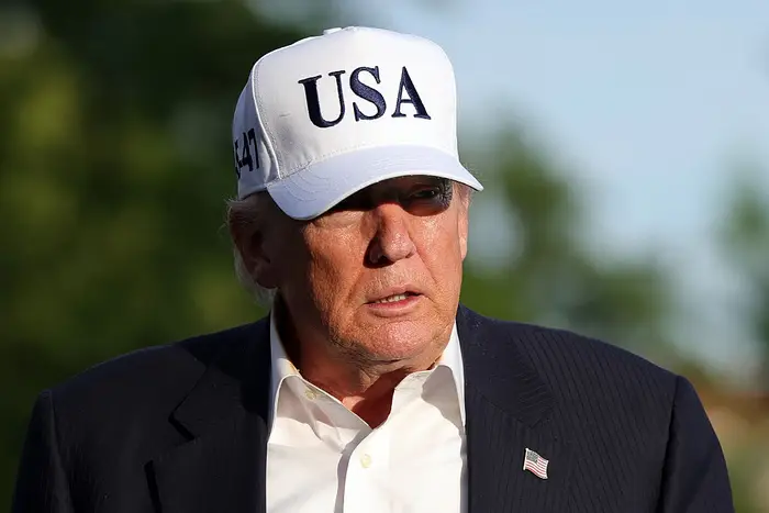 Person som har på seg en dressjakke og en baseballcaps med