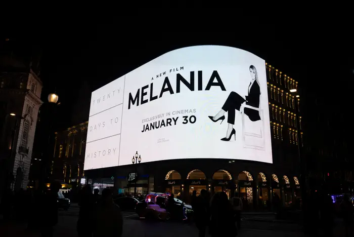 Billboard med en filmannonse for "Melania," viser en stilig kledd person med teksten