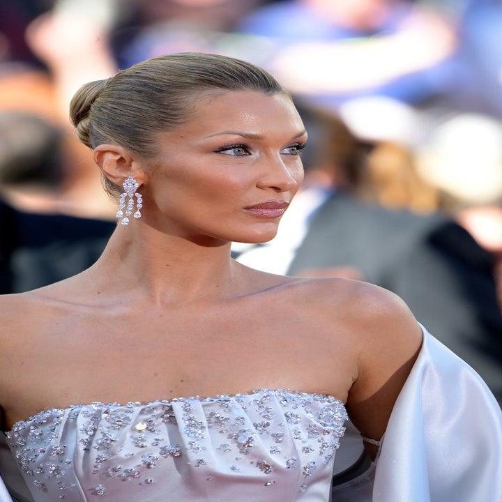 Person i elegant stroppeløs kjole utsmykket med paljetter, iført øredobber, hår i en elegant updo, på det som ser ut til å være en formell begivenhet