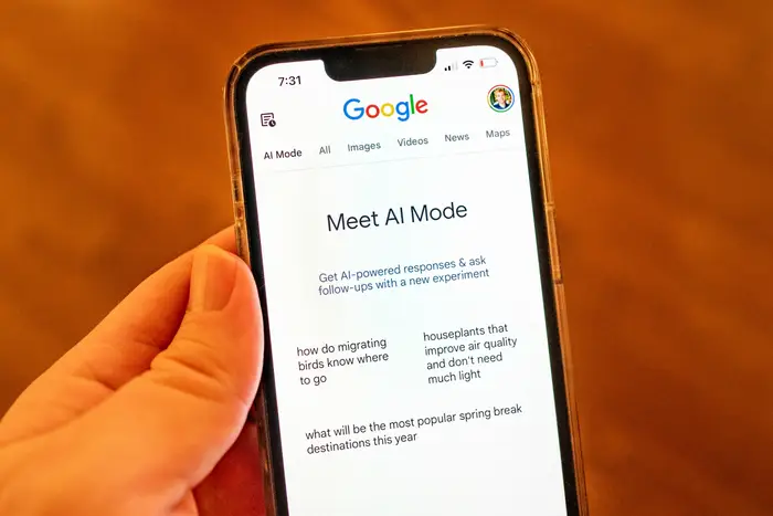 Person som holder en smarttelefon som viser en Google-søkeside med tittelen 