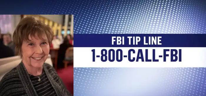 Smilende kvinne som sitter på en restaurant ved siden av en FBI-tipslinjes kontaktinformasjon