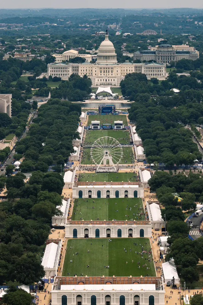 Luftfoto av National Mall i Washington, DC, med US Capitol og et stort pariserhjul, omgitt av arrangementstelt og folkemengder
