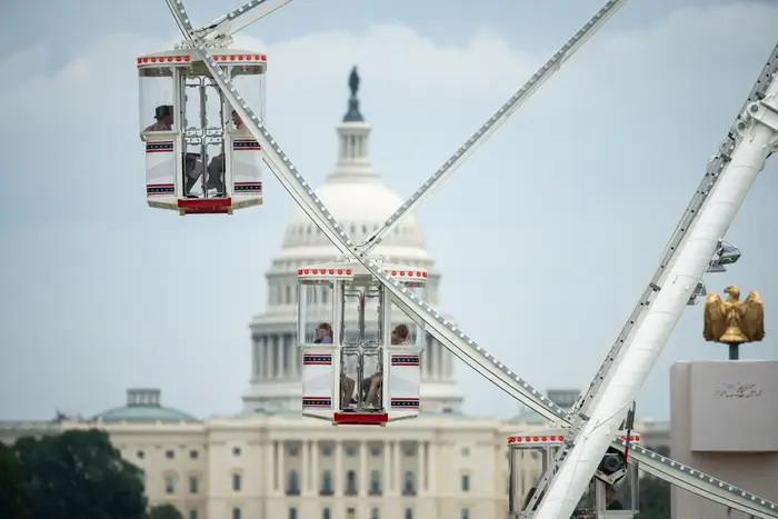 Pariserhjulsgondoler i bevegelse med US Capitol-kuppelen synlig i bakgrunnen