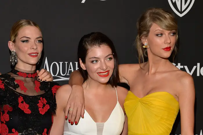 Jaime King, Lorde og Taylor Swift poserer på den røde løperen i elegante kjoler mens Taylor legger en arm rundt Lorde