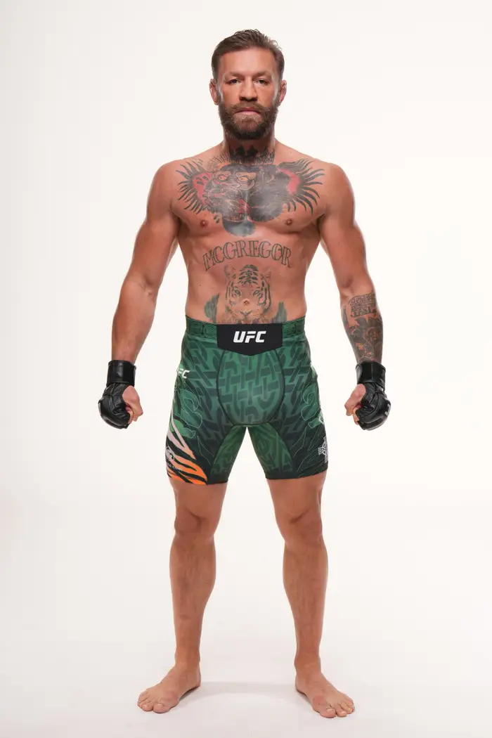 Conor McGregor i mønstrede shorts og hansker, som viser frem flere tatoveringer, står i en selvsikker positur