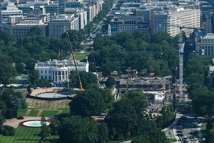 Luftfoto av Det hvite hus omgitt av pågående byggearbeid og utstyr, med bybildet i bakgrunnen