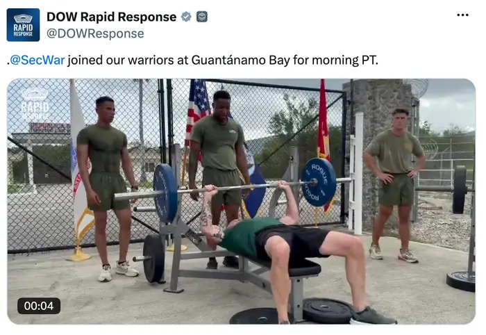 Militært personell i treningsutstyr utfører en benkpress med vektstang utendørs ved Guantánamo Bay