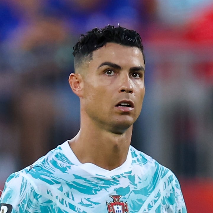 Fotballspiller i en Portugal-trøye med #7, fokusert under en kamp, iført et kapteinsbind