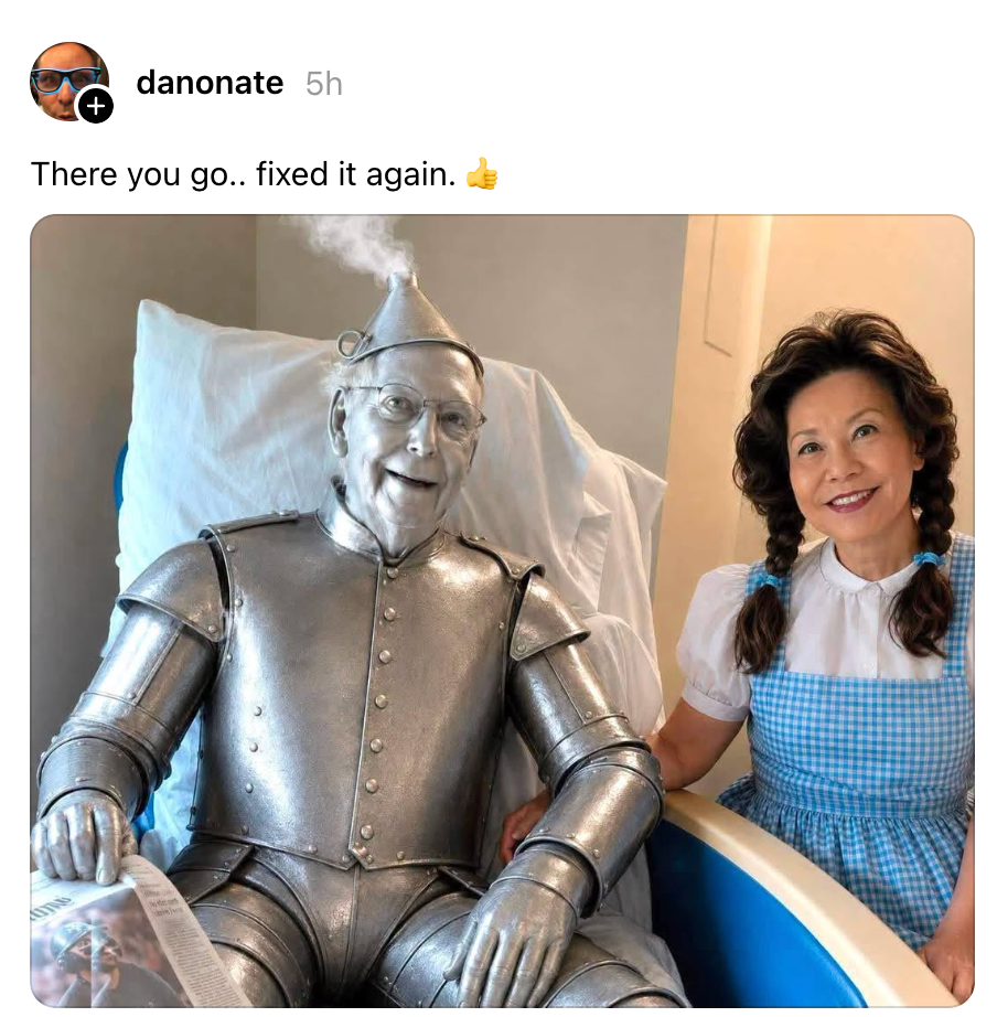 Person i et Tin Man-kostyme med damp som stiger opp fra hodet, sitter ved siden av en annen person kledd som Dorothy i en blårutete kjole