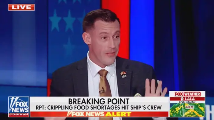Mann i dress gestikulerer under en direktesendt nyhetssending som diskuterer matmangel som påvirker et skips mannskap; Fox News varslingsbanner nederst