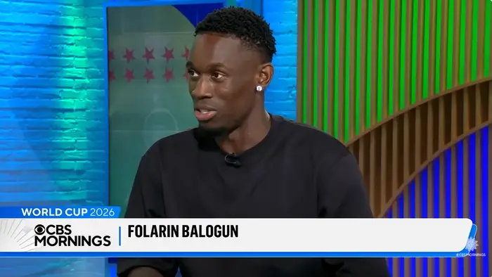 En person blir intervjuet på CBS Mornings om verdensmesterskapet i 2026, iført en uformell svart genser