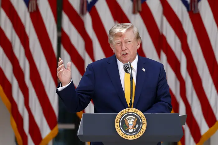 Person som snakker på et podium med presidentens segl, foran flere amerikanske flagg
