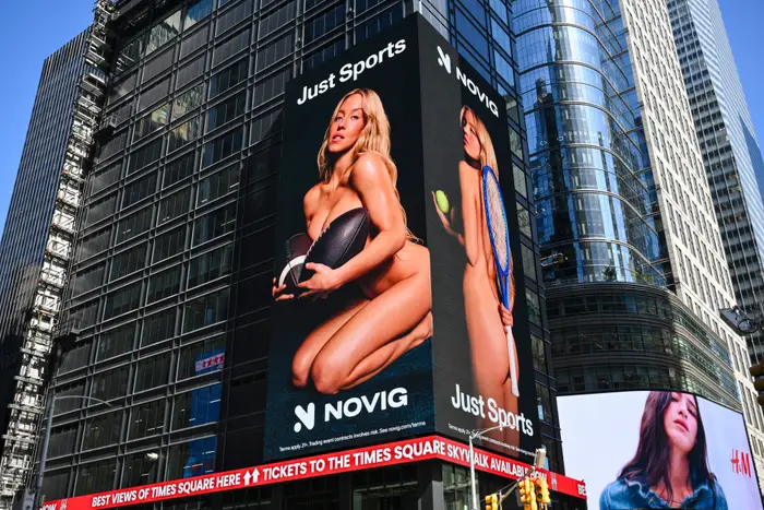 En stor reklametavle på Times Square viser en person som poserer med en fotball- og tennisracket, og promoterer