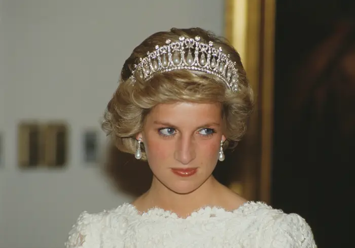 Person i elegant antrekk med tiara og perleøreringer