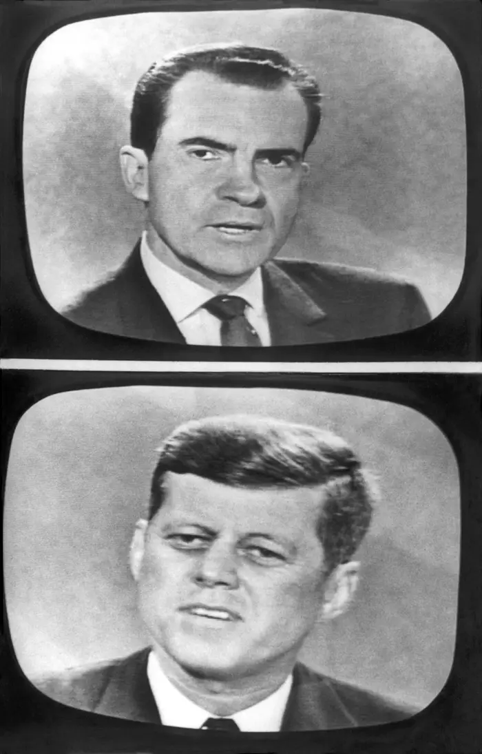 Nixon og Kennedy i dress vises på delte TV-skjermer, engasjert i en debatt, hver med fokuserte uttrykk
