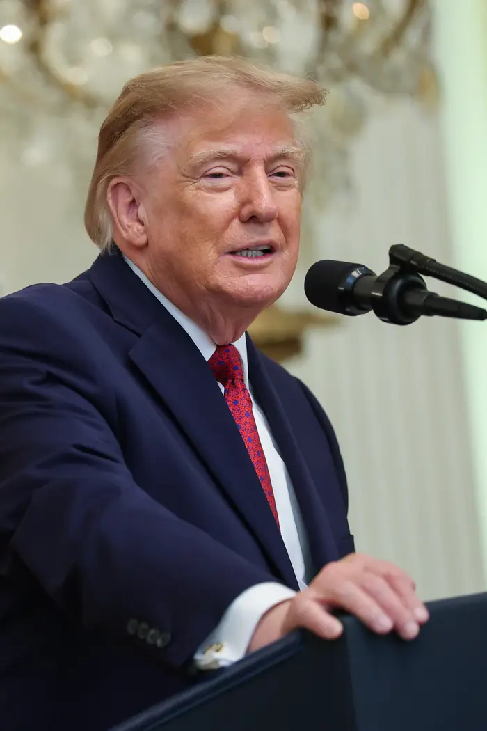Trump i dress taler ved podiet med mikrofon innendørs